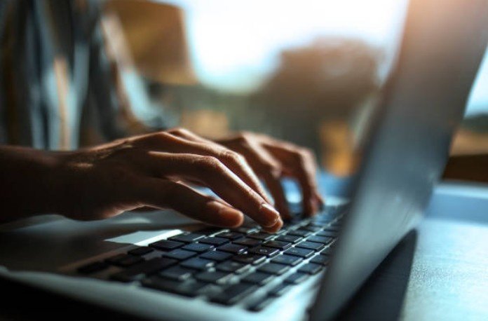 A close-up of hands on a laptop. Users often search for how to duplicate a page in wordpress to streamline content creation.